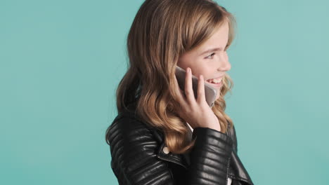 teenage caucasian girl in leather jacket talking on the phone.