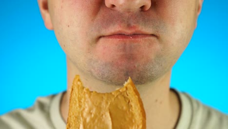 man biting and eating peanut butter sandwich. close up of lower half male face, eating sweet food