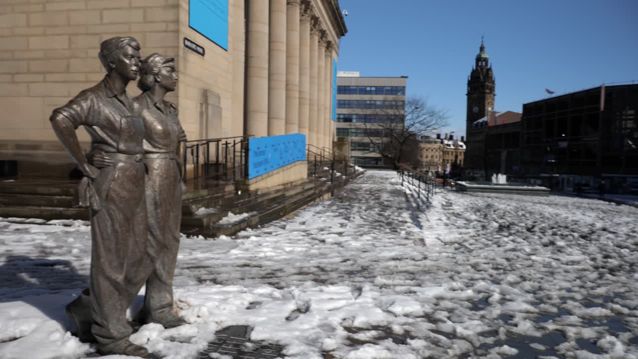 화창한 날 셰필드의 눈 덮인 광장에서 시청과 조각상으로 패닝하는 카메라