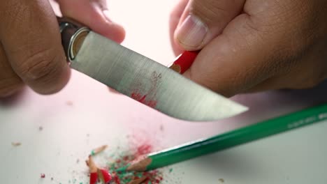 Footage-of-hands-slowly-sharpening-a-pencil-and-some-coloured-pencils-with-a-sharp-knife