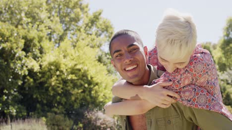 Portrait-of-happy-diverse-friends-playing-in-garden-in-summer