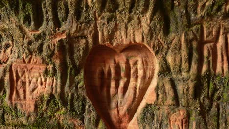 Tourist-wall-scrapings-on-a-sandstone-wall-in-Gutmanis-Cave,-Sigulda,-Latvia