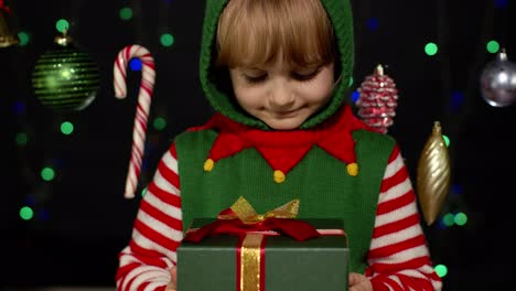 Kid-girl-in-Christmas-elf-Santa-Claus-helper-costume-getting,-receiving-surprise-gift-box,-happiness