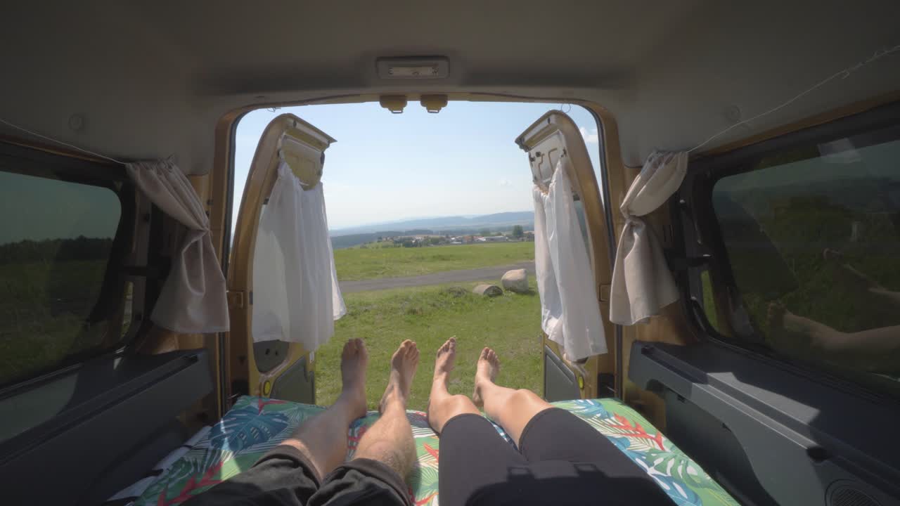 캠퍼 밴 안에서 일제히 발을 움직이며 누워있는 유목민 부부
