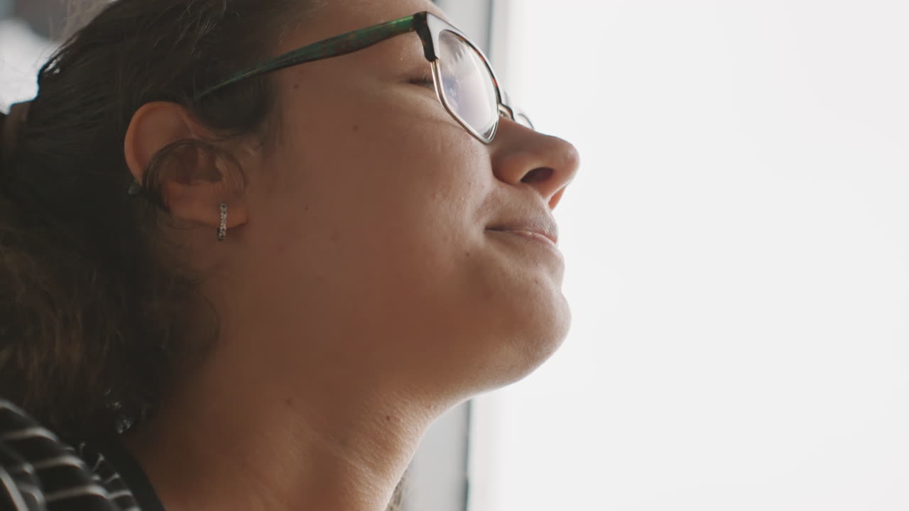 Donna che si gode placidamente il suo tè vicino alla finestra. Ospite femminile rilassata che assapora una bevanda calda vicino alla porta d'ingresso illuminata dal sole. Donna allegra che si rilassa con una tazza di tè mentre guarda fuori dalla finestra.