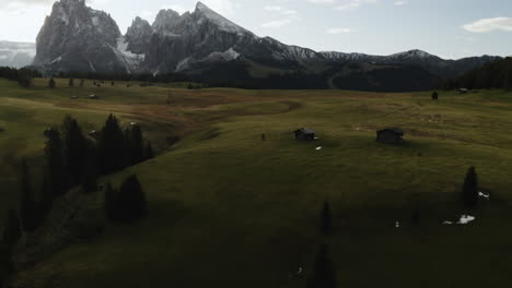 Aerial-view-tilting-over-cloudy-meadows-with-the-Seiser-Alm-mountains-in-the-background,-in-Tyrol,-Italy