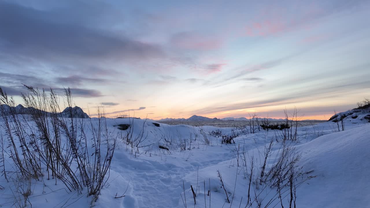 Snowy landscape during sunset in Svolvær with serene mountain and sky views