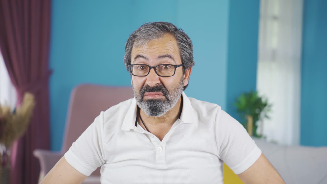 중년 남자가 카메라를 쳐다보고 혐오감을 느 ⁇ 습니다.