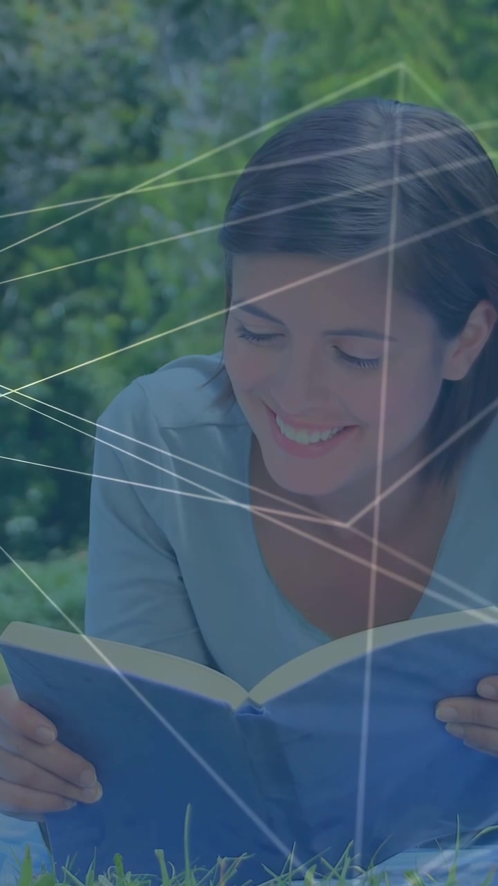 Vídeo vertical: Mulher lendo livro azul na grama, virar a página causando sobreposição de rede tecnológica para estudo