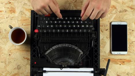 Hands typing on a vintage typewriter