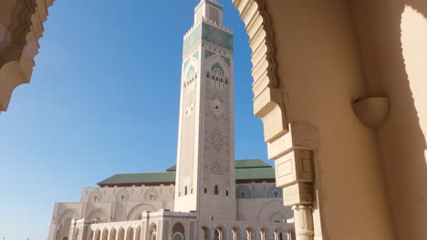 caminar bajo los arcos revela la gran mezquita de hassan ii y el altísimo minarete