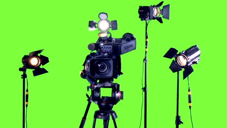 professional studio spotlights and a professional video camera on a green screen.