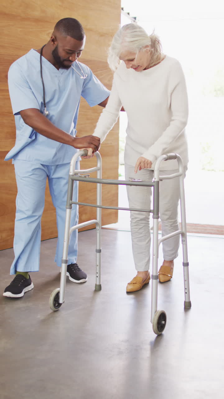 행복한 아프리카계 미국인 남성 물리 치료사가 고령 환자와 함께 운동하는 수직 비디오