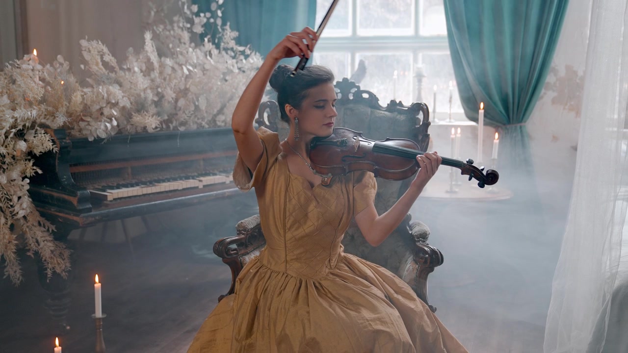 Donna elegante in abito dorato che suona il violino in una stanza vintage