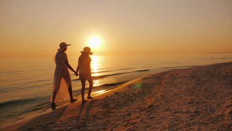 Mom-And-Daughter-Are-Walking-By-The-Sea-At-Sunset-Holiday-With-A-Child-Concept-Steadicam-Shot