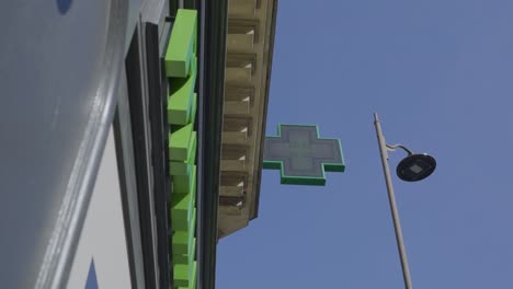 green pharmacy cross sign against a bright sky in paris, france, capturing the vibrant atmosphere