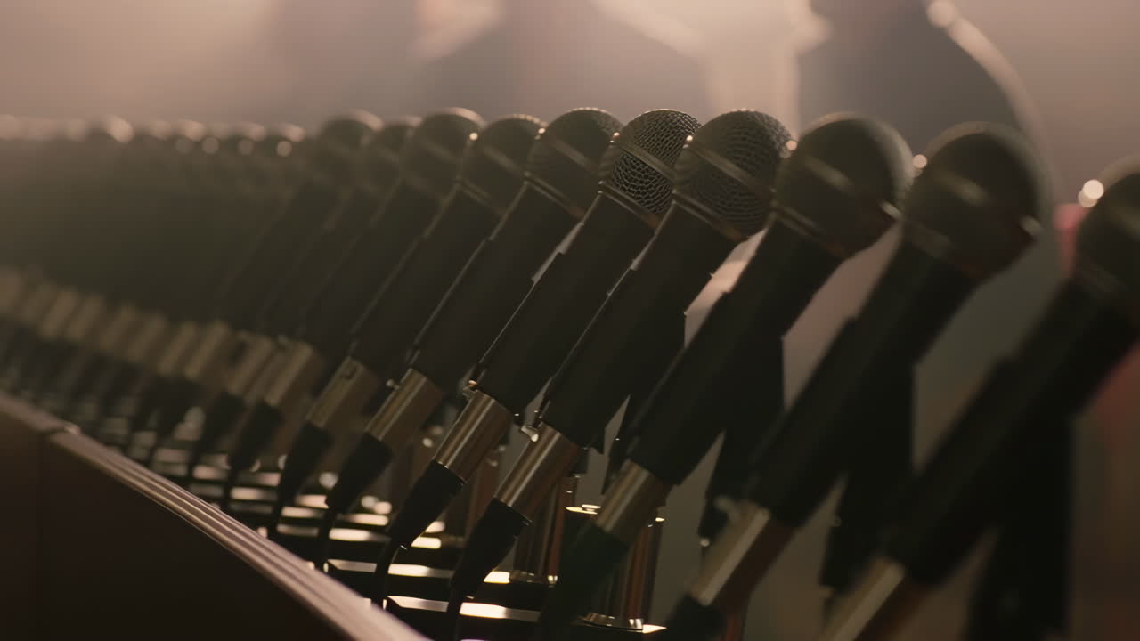 A long row of microphones set up for a press conference or event