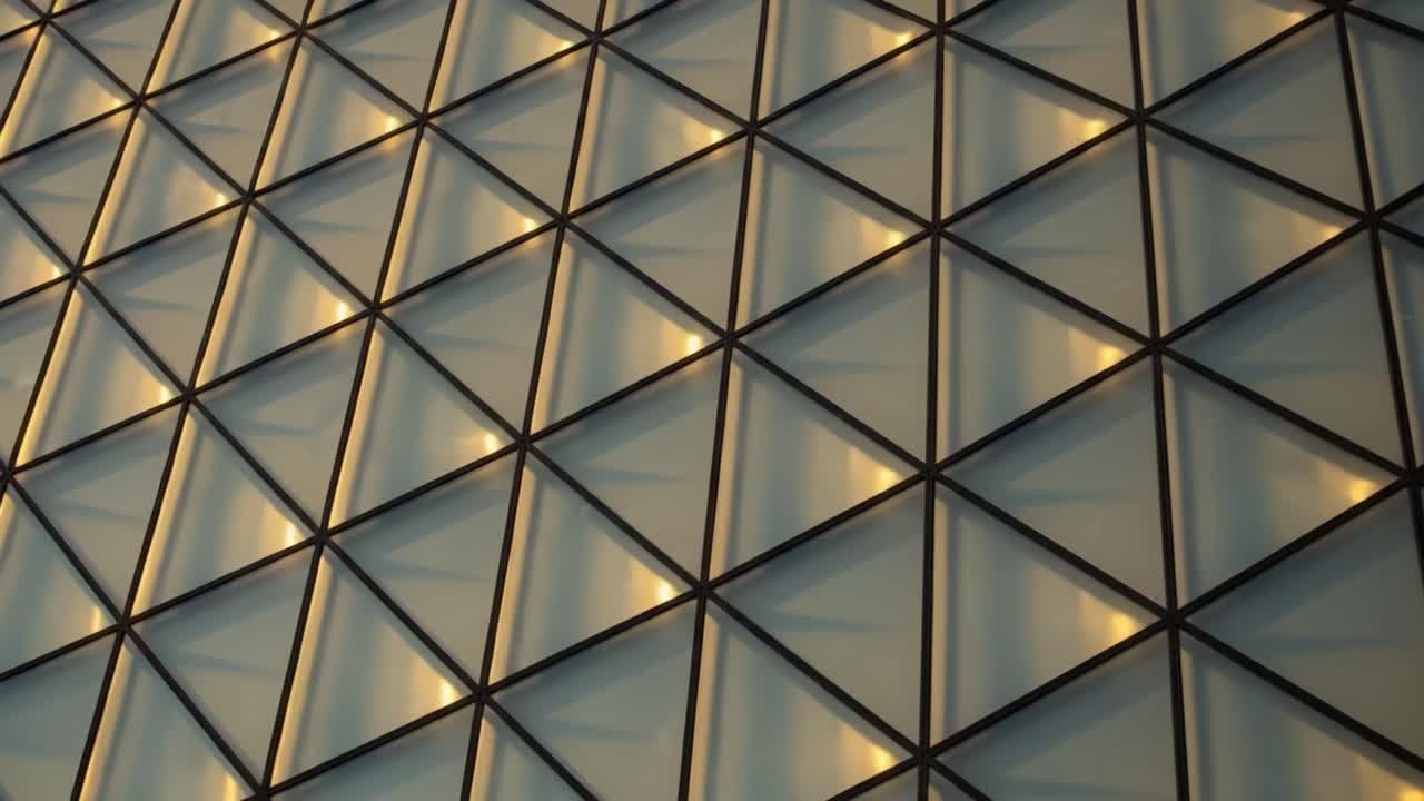 Intricate Geometric Patterns Captured on a Modern Architecturally Designed Facade, Showcasing Light Reflections Across Triangular Glass Elements