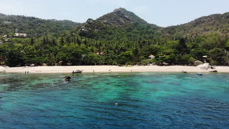 drone flight towards tanote bay beachfront in koh tao, thailand, with a drone