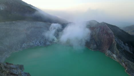 drone shot ijen acid lake with beutiful white cloud floating in the midde of the lake in java indonesia
