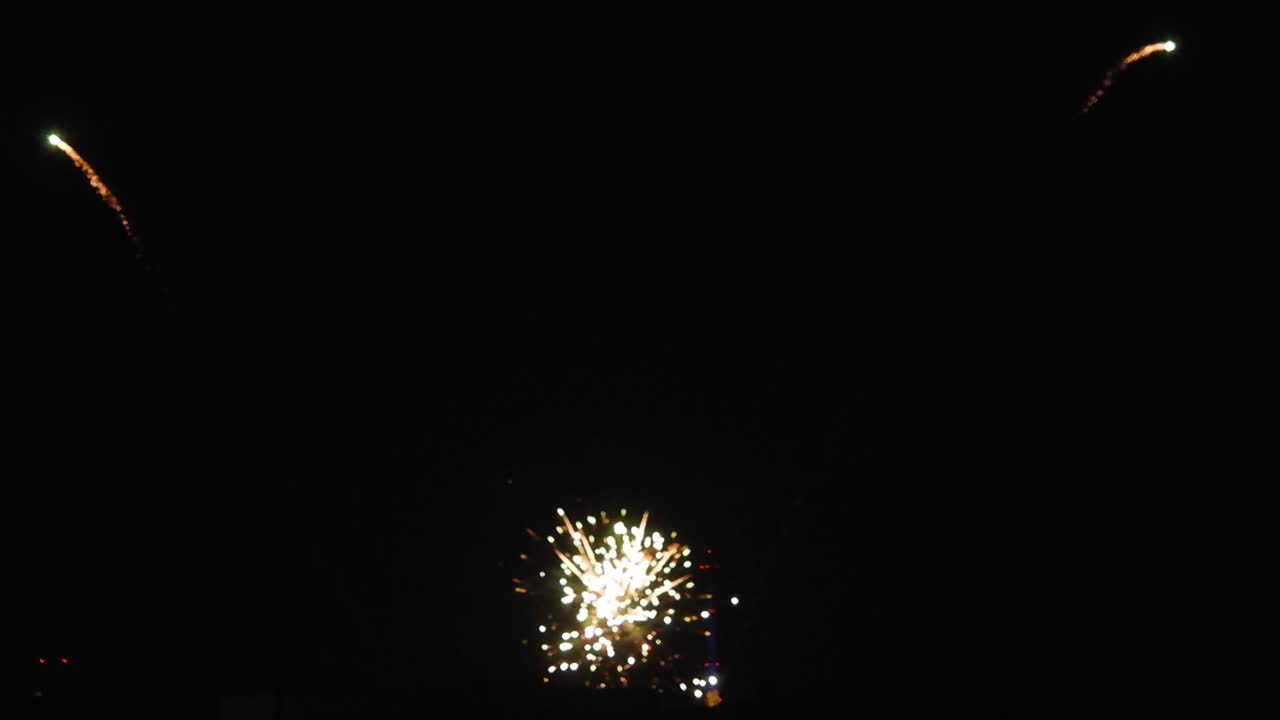 Fuochi d'artificio nella notte scura in diverse forme e colori che celebrano il nuovo anno.