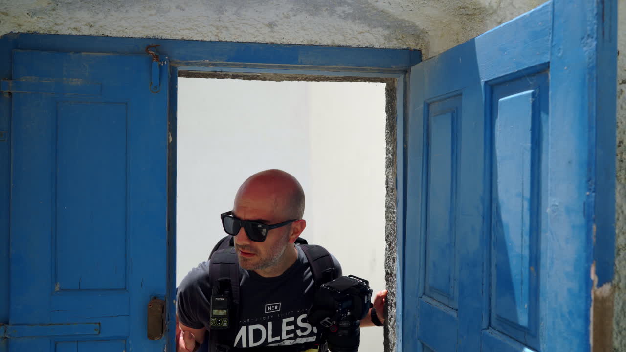 hombre α mira a través de una puerta azul abierta