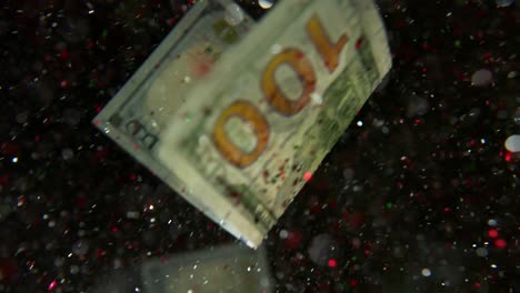 falling flying american dollar banknotes and flying mixing with the glitter sparkles on a black background in 4k loopable. high quality falling dollar banknotes in 4k. video is loopable