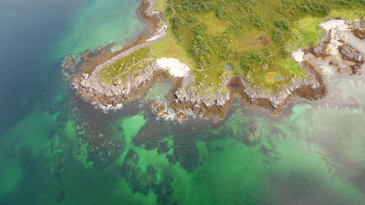 Vista de drone do impressionante litoral ártico em Årnessan, com água turquesa cristalina, costas rochosas e pequena praia de areia perto de Stokmarknes, Noruega. Aéreo de cima para baixo para trás
