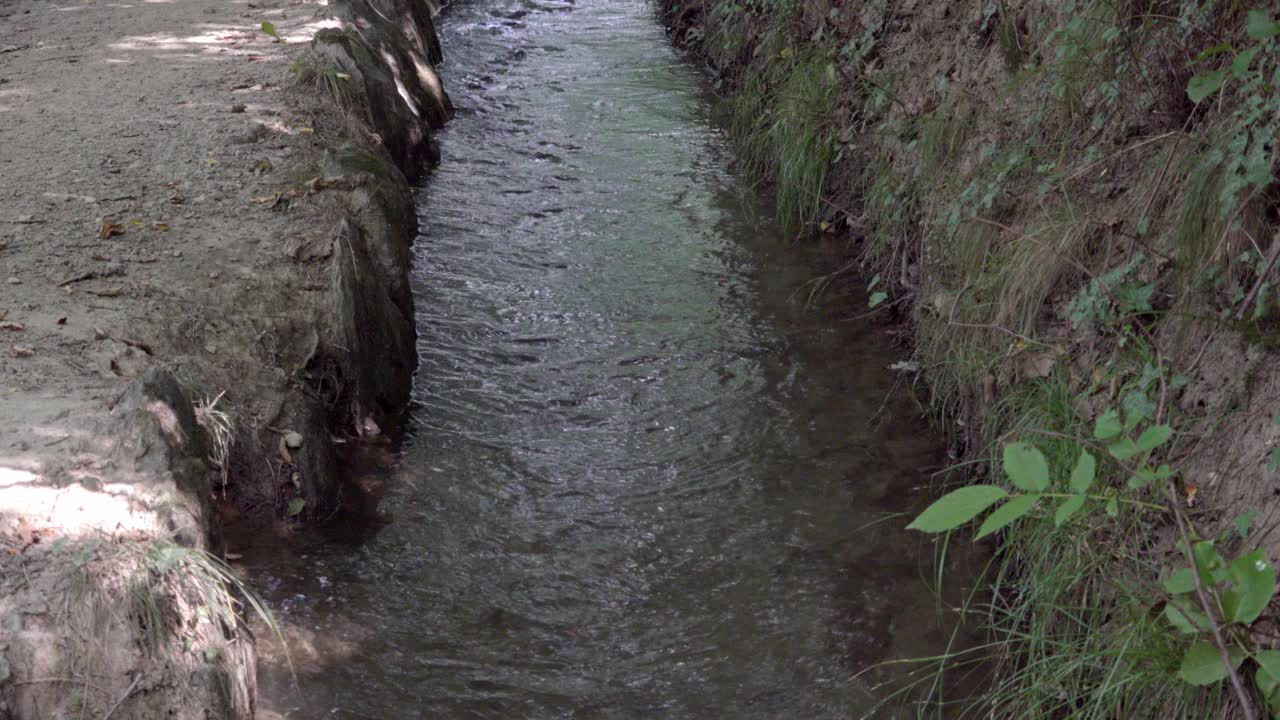 다양한 용도로 물을 운반하기 위해 설계된 관개 운하의 일부의 클로즈업. 관개 운하를 따라 산책 경로가 이어집니다.