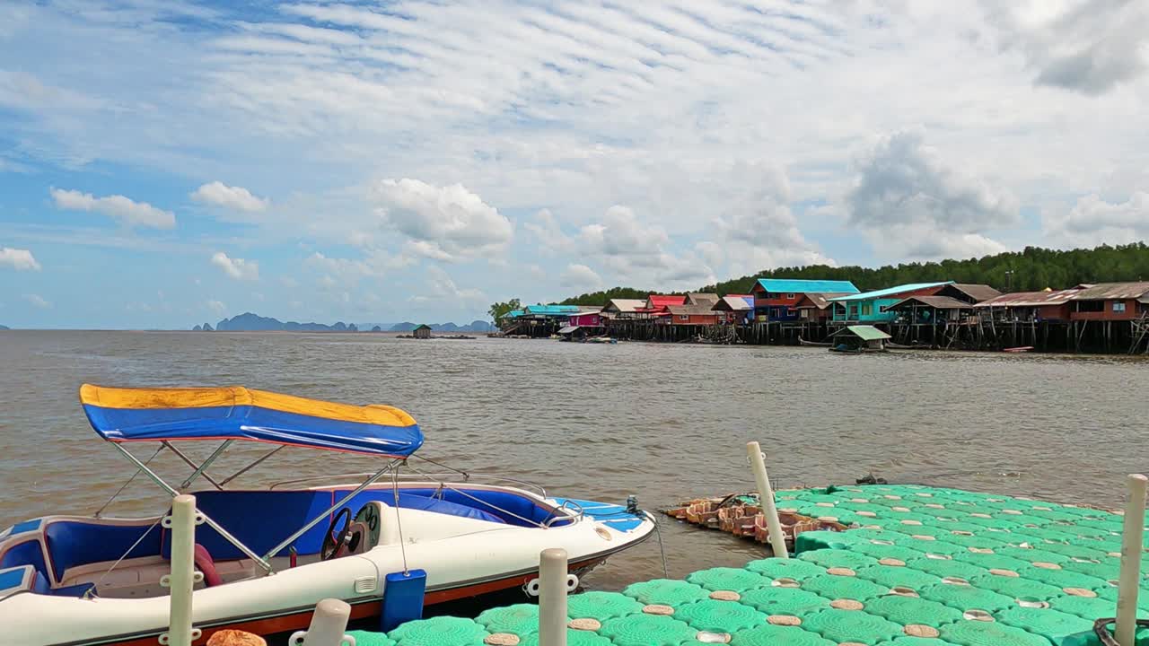 Speed boat at local village pier on yellow green sea water