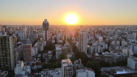 aerial pan right of belgrano neighborhood buildings and skyscrapers at sunset with bright sun, buenos aires, argentina