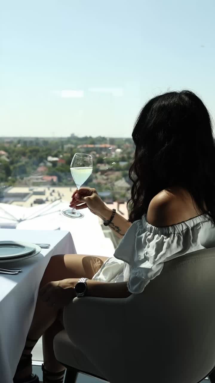 Woman Enjoying Wine with a City View