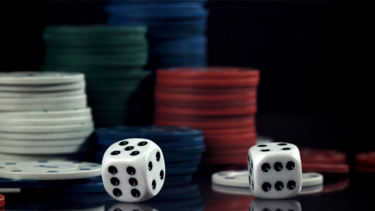 Dadi da gioco che cadono al rallentatore con fiches da poker sullo sfondo