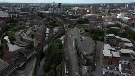 aerial drone flight over castlefield with a view of the quays and moving trams below