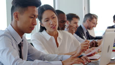 group of businesspeople meeting around table in boardroom