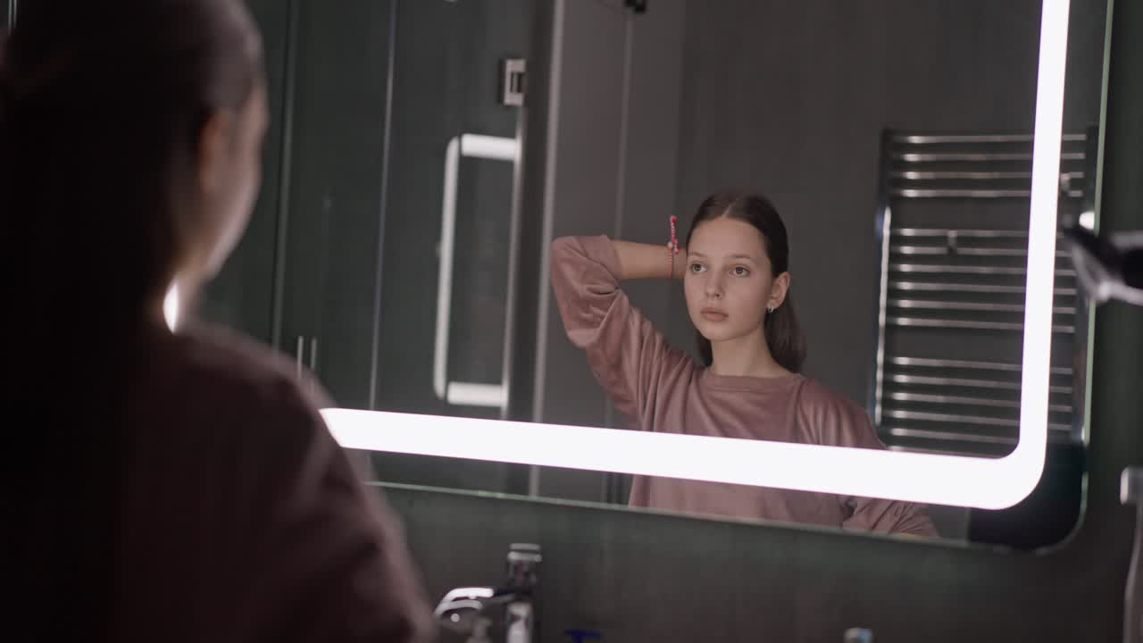 Girl Looking in Mirror in Bathroom