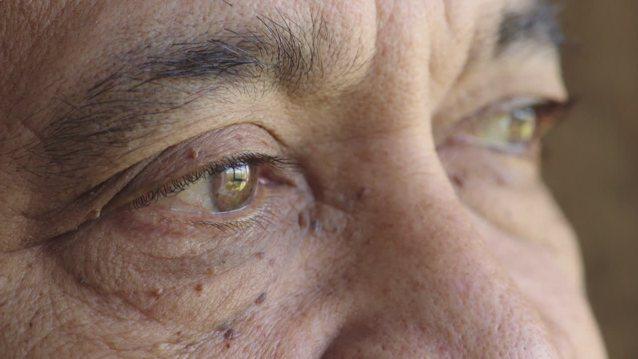 close up of elderly man eyes looking pensive contemplative