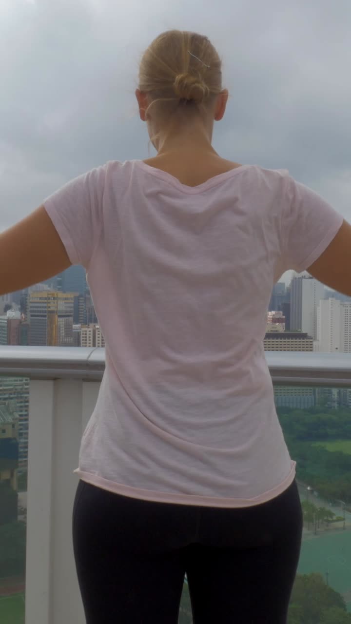 Woman Doing Dumbbell Lateral Raises on City Rooftop