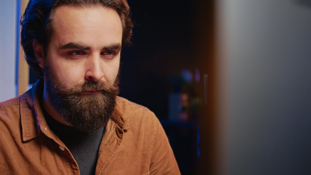 Focused software developer in home office doing coding on computer, close up