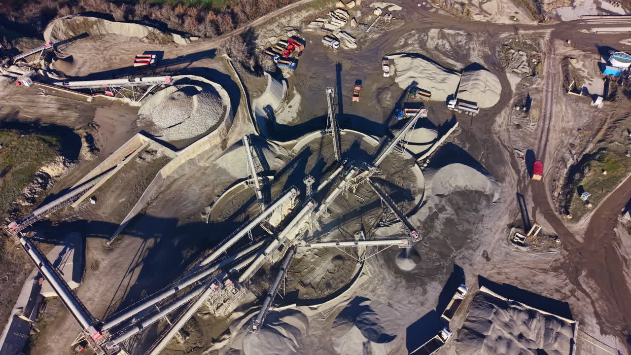 Construction site bustling with activity showing machinery and materials being processed under clear blue skies