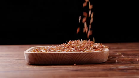 una variedad de diferentes colores de alimentos de granos crudos saludables, varios granos, cereales, frijoles, legumbres se rotan en decoración de madera para el concepto de publicidad