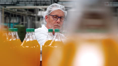 trabajador examinando una botella en una fábrica