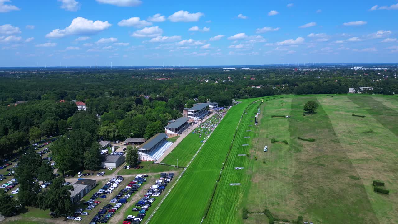 horse racing track with spectators enjoying the competition on a sunny summer day. Lovely aerial view flight overflight flyover drone