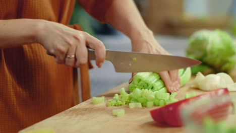 Woman-chopping-celery-on-cutting-board