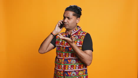man discussing with friend over telephone call, studio background