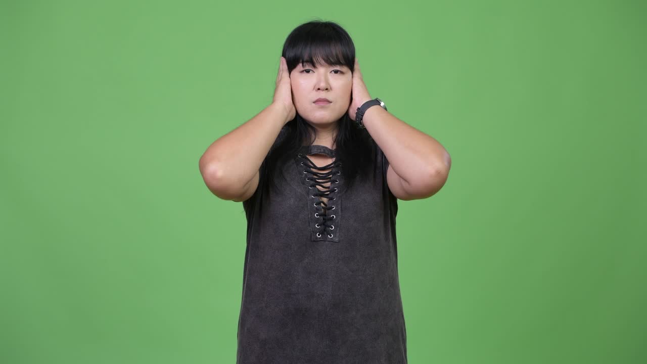 Beautiful overweight Asian woman covering ears as three wise monkeys concept
