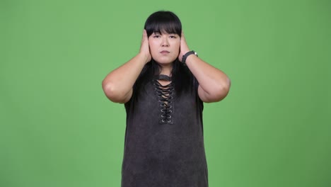 beautiful overweight asian woman covering ears as three wise monkeys concept