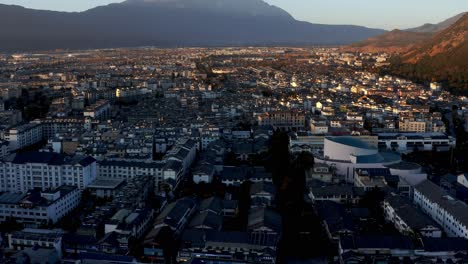 Dramatic-Lijiang-city-with-Jade-Dragon-Snow-Mountain-background,-China,-aerial