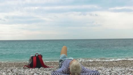 woman relaxing on a pebble beach