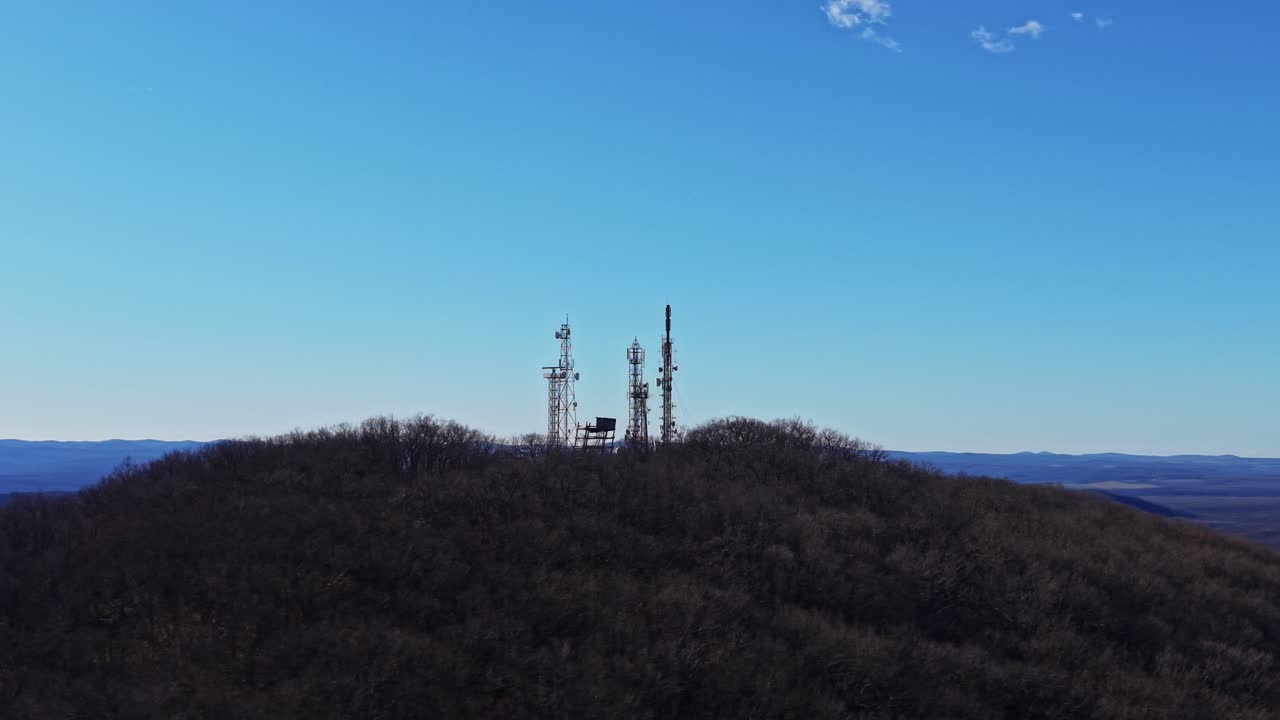 Torri di telecomunicazione sulla cima di una collina alla luce del giorno